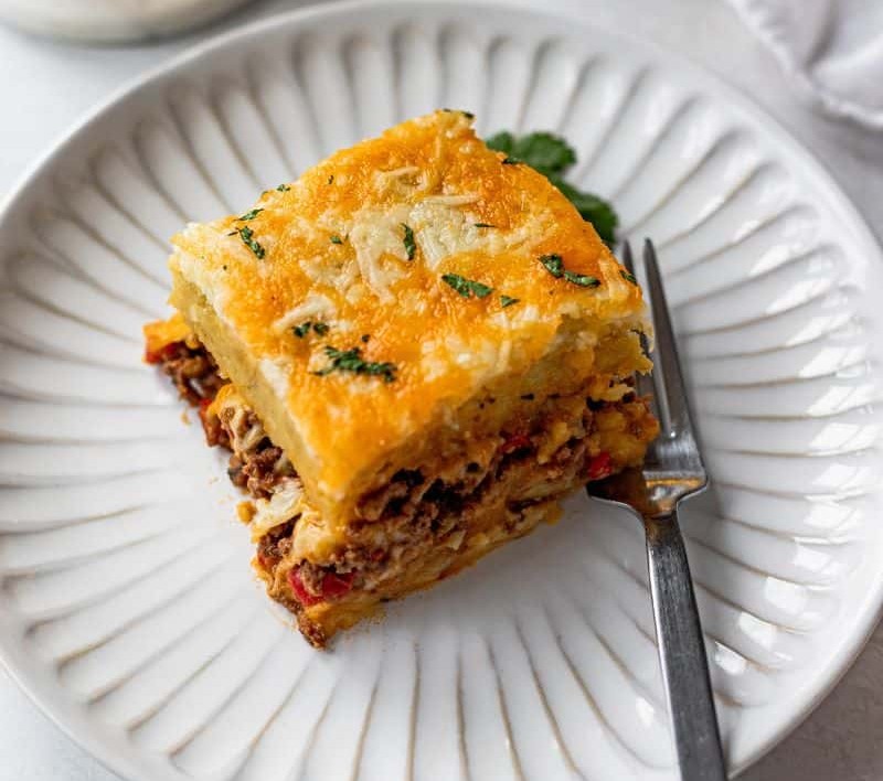 Layered pastelón (plantain lasagna) in a baking dish
